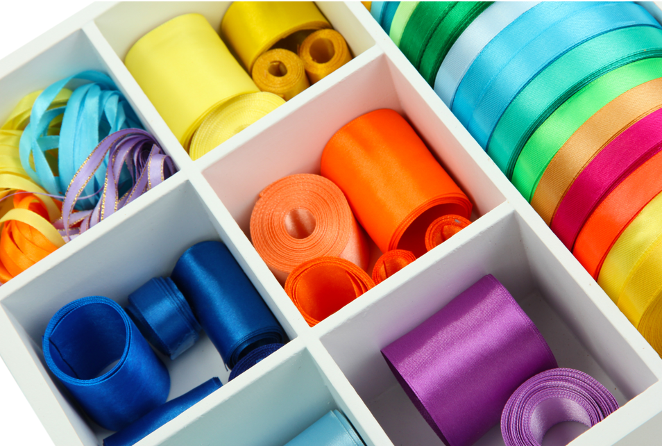 Storage box divider separating colours of ribbon.