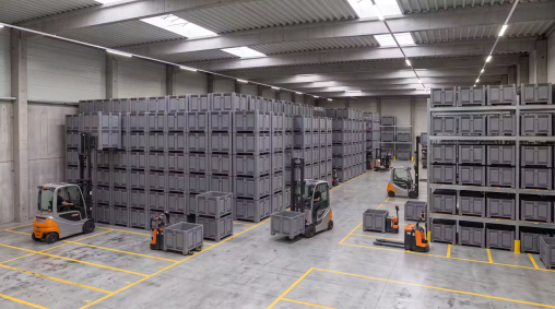 Stacks of pallet boxes with forklifts in a warehouse facility