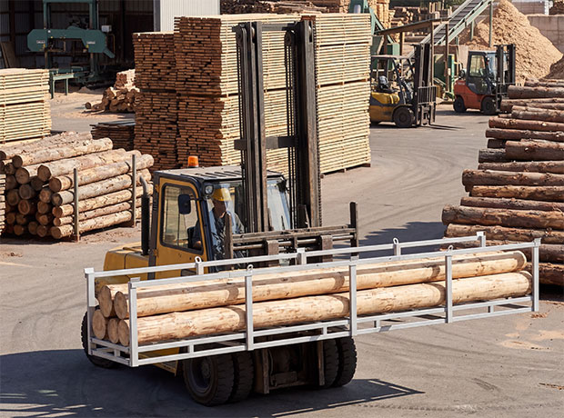 Timber being moved by a forklift in a timber yard in a pipe stillage