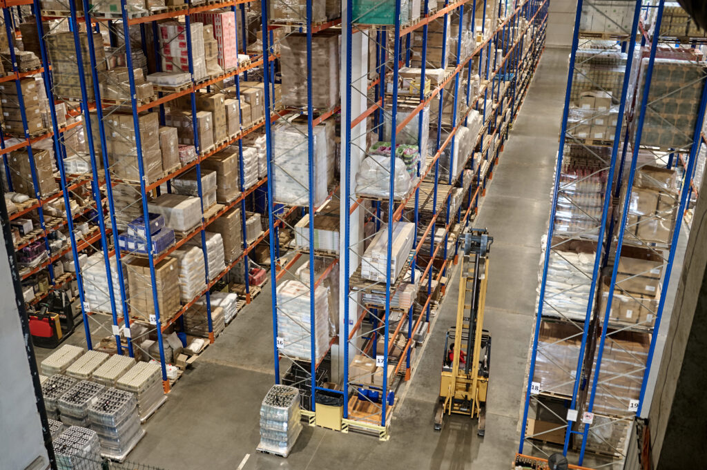 Top view looking onto high racking with a pallet stacker truck working in one of the aisles.